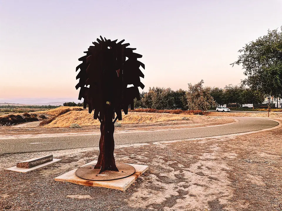 A metal silhouette sculpture beside the Lewis S. Eaton Trail at sunset