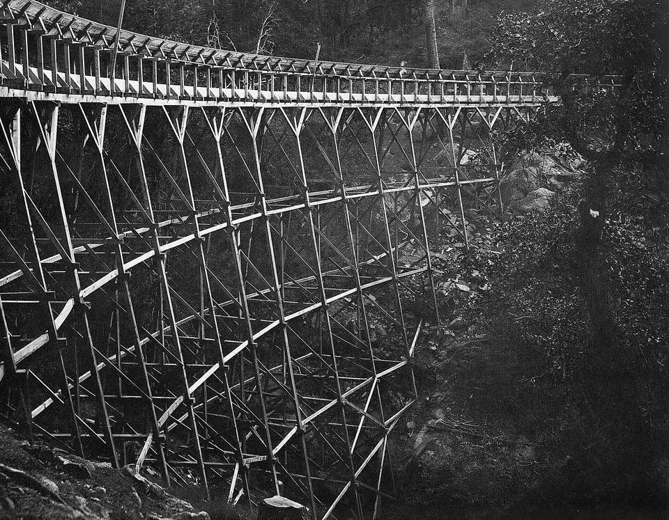Historic black-and-white photo of a timber lumber flume trestle near Shaver Lake